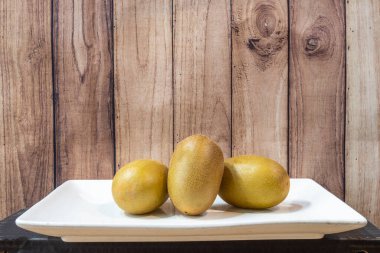 Olgun yeşil kivilerle dolu beyaz tepsi yemeye hazır.