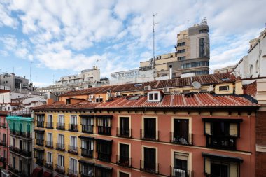 Facades of vintage urban residential buildings with clay roofs and small windows in the attics