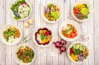 Set of white bowls full of vegetarian salads of all kinds, fresh, energizing and healthy