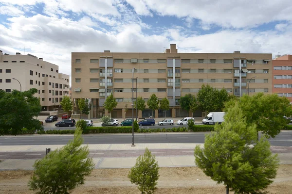 Bulutlu ve berrak bir gökyüzü ile sokaktan görülen modern kentsel yerleşim binalarının cepheleri