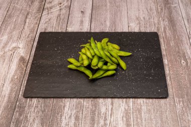 Edamame Japonca 'da olgunlaşmamış soya kabuklarının pişirilmesi anlamına gelir. Tuzlu suda kaynatılır ve bütün olarak servis edilir.