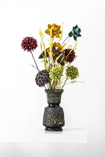 Black stone vase with dried flowers and plants