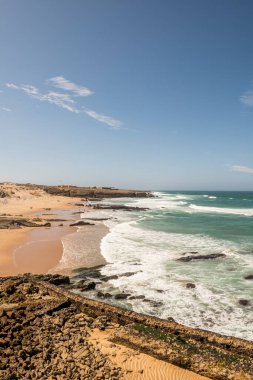 Beach with sand and rocks and plenty of waves on the Atlantic coast of Portugal