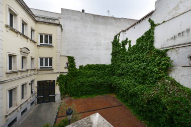 Inner courtyard of a palace with a vine-covered wall and mud floors