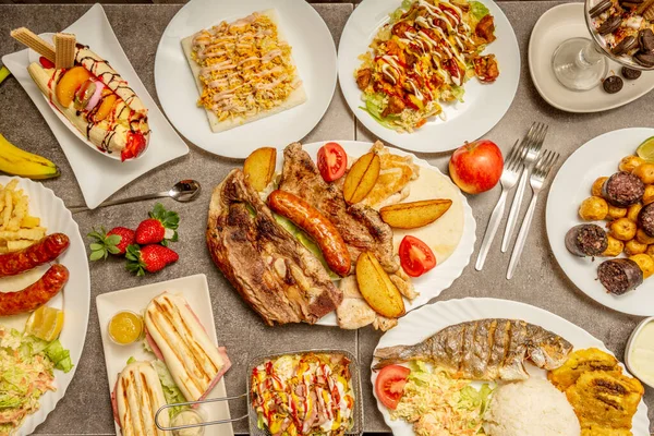 Caribbean-style food recipes with grilled fish, barbecued meat, patacones, hot dog with fruits, patacon with torrezno