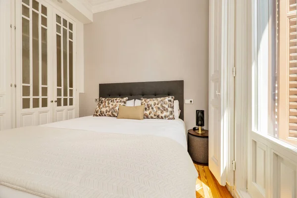 Спальня Ліжком Обтягнутим Сірою Тканиною Відповідними Подушками Подушками Великим Балконом — стокове фото