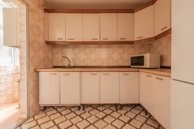 Eski mobilyalar, eski fayanslar, döşemeler ve ahşap tezgahla döşenmiş mutfak.
