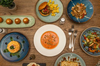 Modern İspanyol yemeklerinin tarifleri ve boletus kroketli tapas, beyaz tabakta salmorejo, Rus salatası ve tavuk ve pirinç güveci.
