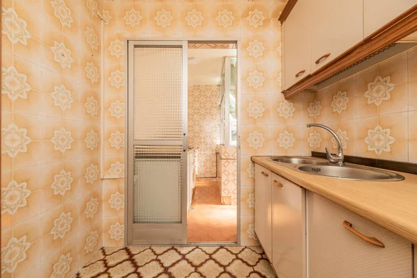 Vintage floral tiled kitchen with matching flooring and wood cabinets