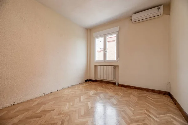 empty room with gleaming herringbone oak parquet floors and air conditioning unit on the wall