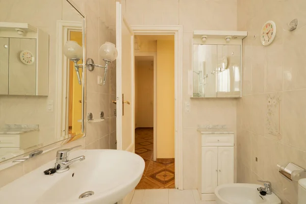 Wcは白い色調で壁に鏡 白い磁器の衛生器具と漆塗りの木製家具 — ストック写真