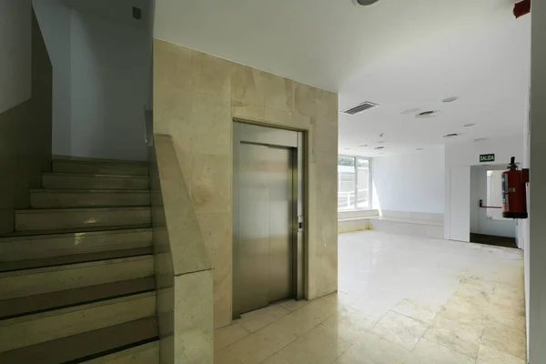 Hall of a residential building with elevator and marble stairs