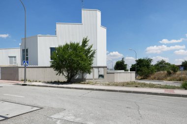 Beyaz çatılı ve yakındaki ağaçlarla endüstriyel depo cephesi