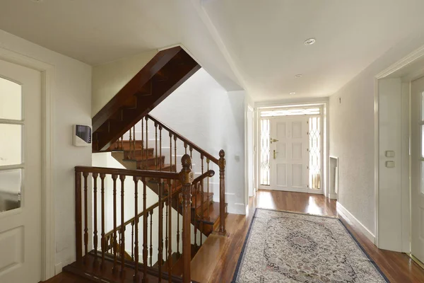 Hall of a single-family home entrance door with distribution wooden stairs to the different levels