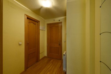 Meşe kapılı, zeminleri uyumlu ve sarı duvarları olan bir evin dağıtıcısı.