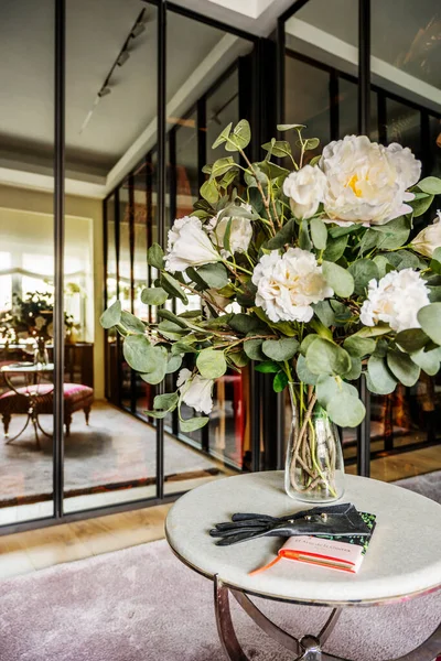 Dressing room in a bedroom with glass and mirror doors with a fresh flower centerpiece