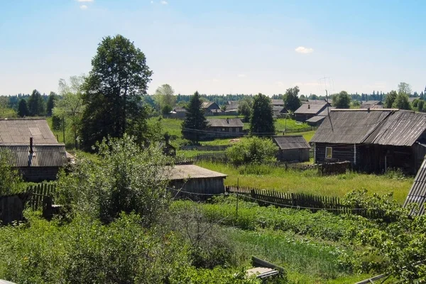 Eski bir köy, ahşap harap evler. Tahta çit. Yaz. Gün.