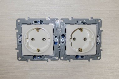 Duvar kağıdıyla kapağı olmayan çift elektrik prizi. Rengi fildişi.. 