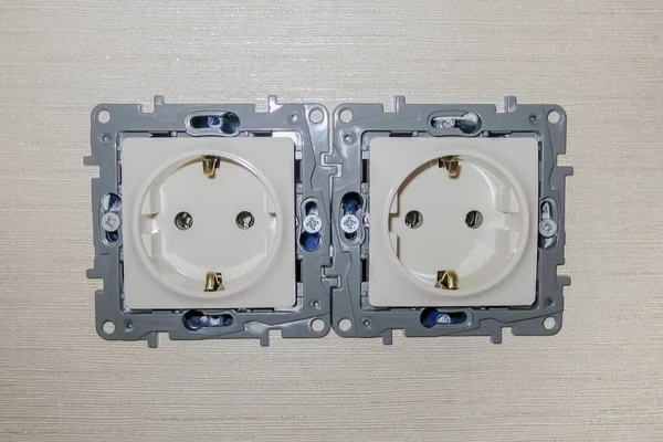 Duvar kağıdıyla kapağı olmayan çift elektrik prizi. Rengi fildişi.. 