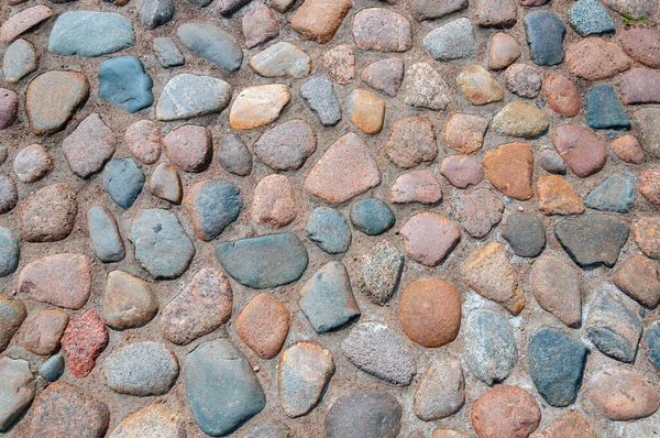 The texture or background is a sidewalk paved with cobblestones of different colors. Top view — Stock Photo, Image