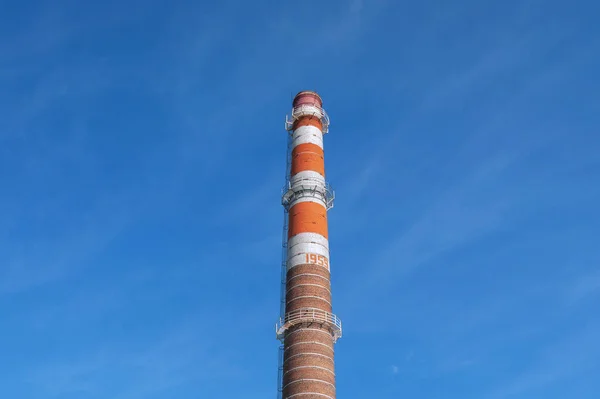 Eski fabrika çizgili, turuncu, kahverengi, mavi gökyüzü arka planında baca