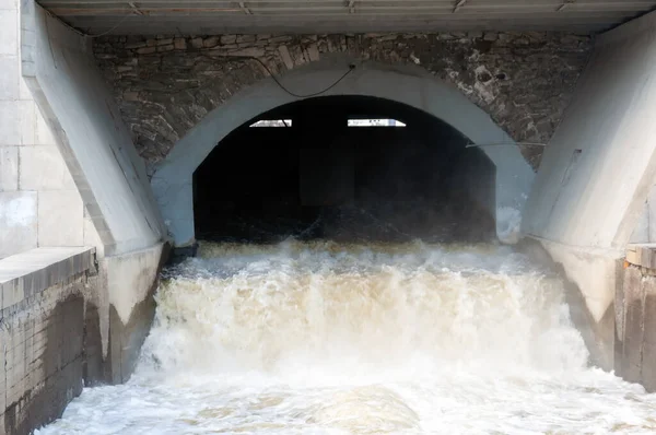 Köprünün altında küçük bir beton baraj, yapay bir şelale.