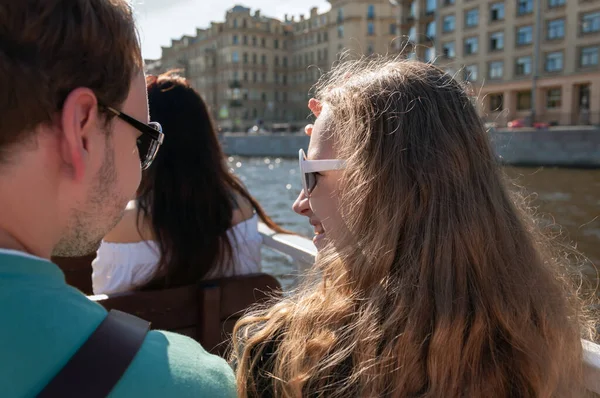 Genç sarışın bir kız ve bir adam zevk teknesinde konuşurken. Yaz, gün, dikiz aynası