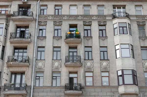 Beton bir binanın gri monoton cephesinde çok renkli yalnız bir balkon.