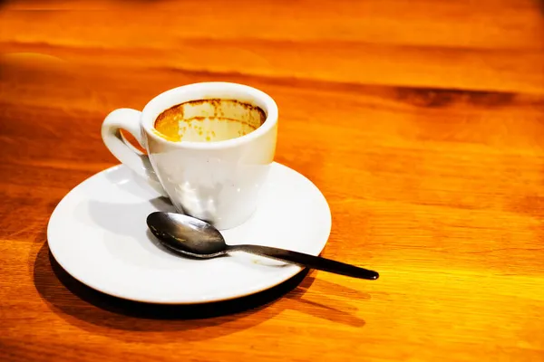 Una taza sucia vacía con los restos de café en la mesa marrón. —  Fotos de Stock