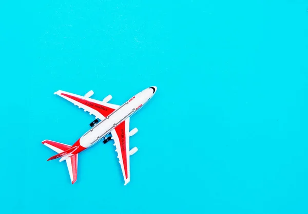 Bílé a červené osobní model letadla na modrém pozadí. Volné místo pro text. Cestovní koncept. — Stock fotografie