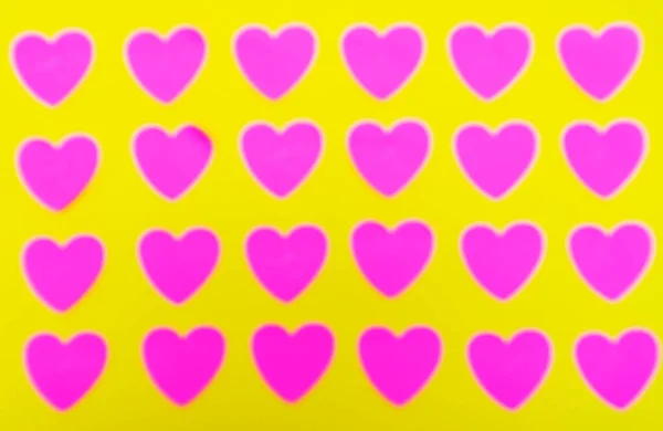 黄色の背景に赤い心。上からの眺め。パターンだ。バレンタインデーだ。背景｜Texture — ストック写真