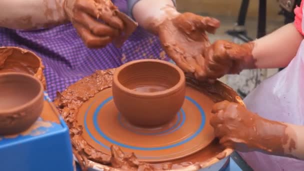 Hands of potter teaches the child how to make pots. Concept - transfer of experience, — Stock Video