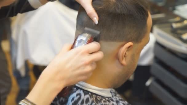 Крупним планом чоловіків стрижка з clipper в перукарні. Стрижка чоловіків перукарні. Чоловіки перукарень. Перукарня ріже клієнтської машини для стрижки. — стокове відео