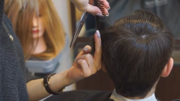 Hombre consiguiendo un corte de pelo por un peluquero. — Vídeo de stock