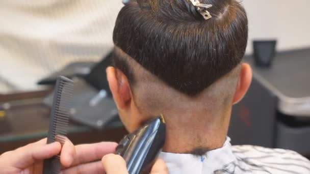 Close up de homens corte de cabelo com cortador de cabelo na barbearia. Homens Cabeleireiros. Barbeiro corta a máquina do cliente para cortes de cabelo . — Vídeo de Stock