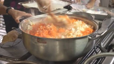 Tanınmayan şef modern otel mutfağında lezzetli vejetaryen yemekleri hazırlıyor. Restoran ziyaretçileri için yemek pişiren profesyonel bir aşçı. Yemek hazırlama konsepti. Ön görünümü kapat.