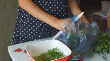 Mutfakta bir kadın taze sebze salatası hazırlıyor.