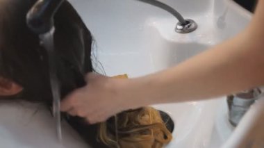 Kuaförler müşterilerinin saçlarını şampuanla yıkar ve saçlarına masaj yaparlar.,