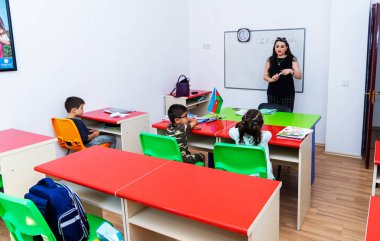 BAKU,AZERBAIJAN-APRIL 17, 2019: children play with toys and engage with the tutor in a kindergarten, school.