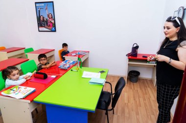 BAKU,AZERBAIJAN-APRIL 17, 2019: children play with toys and engage with the tutor in a kindergarten, school.