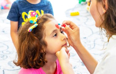BAKU,AZERBAIJAN- 13 MAY 2019 : Girl draws little girl aqua makeup. Face painting. Children leisure