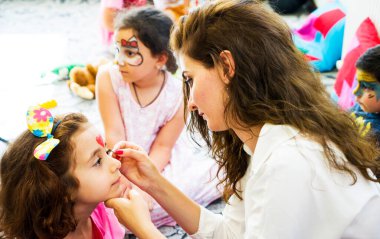 BAKU,AZERBAIJAN- 13 MAY 2019 : Girl draws little girl aqua makeup. Face painting. Children leisure