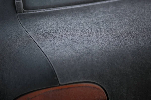 On a crisp, frosty morning, the soft vinyl sliding roof of a car clearly out of the weather as a convertible covered in rain. 