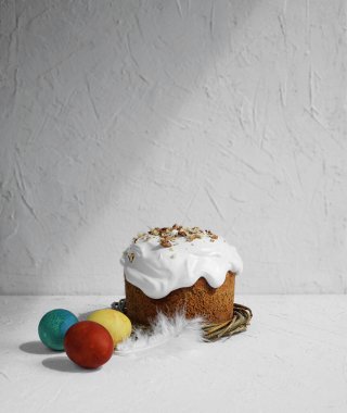 Geleneksel Paskalya pastası güneş altında parlıyor ve bıldırcın yumurtaları ahşap masada kırsal tarzda, pastaya özel olarak odaklanıyor.