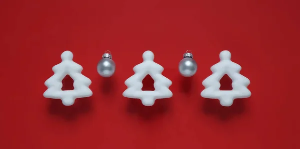 Kırmızı arka planda üç Noel ağacı oyuncağı. - Evet. Üst görünüm