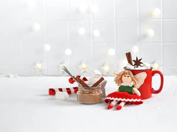 Oyuncak bir peri, kakaolu ve şekerli bir kupanın yanında oturur. Boşluğu kopyala