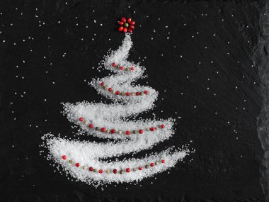 Ringa kemiği şeklinde orta boy deniz tuzu ve taş bir tahtada kırmızı ve yeşil biber. en üstteki görünüm