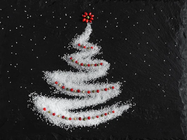 Ringa kemiği şeklinde orta boy deniz tuzu ve taş bir tahtada kırmızı ve yeşil biber. en üstteki görünüm