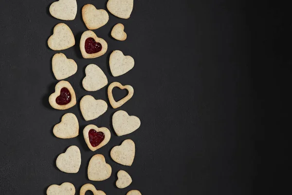 Karanlık masada Sevgililer Günü için kalp şeklinde kurabiyeler. Üst görünüm, boşluk kopyala