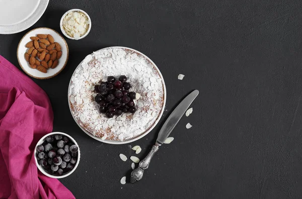 Koyu arkaplanda dondurulmuş böğürtlenli ve bademli turta. Üst görünüm, boşluk kopyala